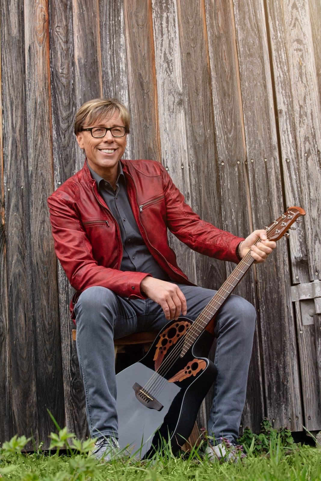 Mit Gitarre an der Holzwand Vorschau